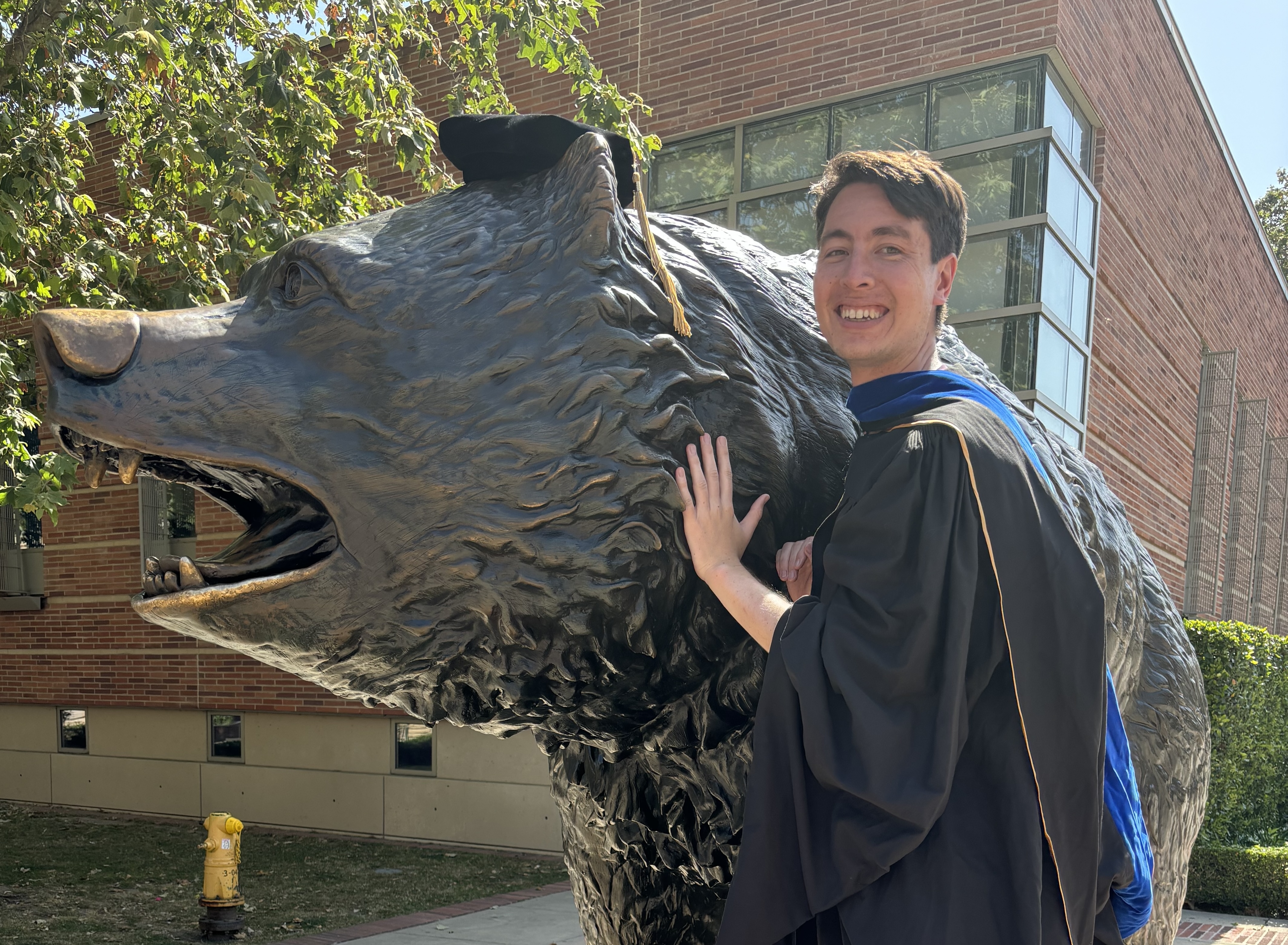 Will celebrating his PhD graduation with the Bruin Bear